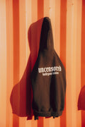 Black hoodie with 'uncensored build your vision' text on a striped orange and red background